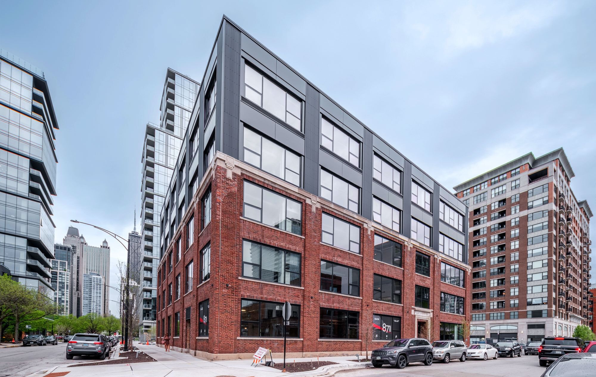 A modern mid-rise condominium building on a residential street in Chicago on a clear day, photographed from the sidewalk