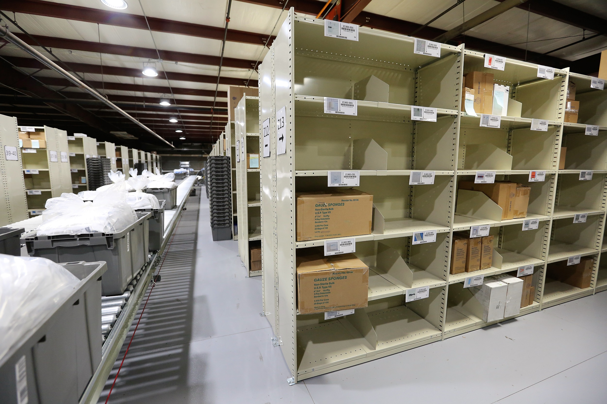 A small warehouse aisle with neatly stacked boxes on metal shelves, showing inventory stored for a growing business