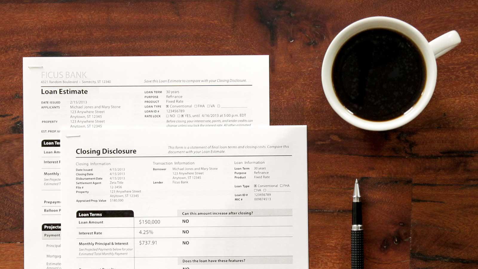 Hands reviewing a mortgage loan estimate document on a desk beside a pen and calculator.