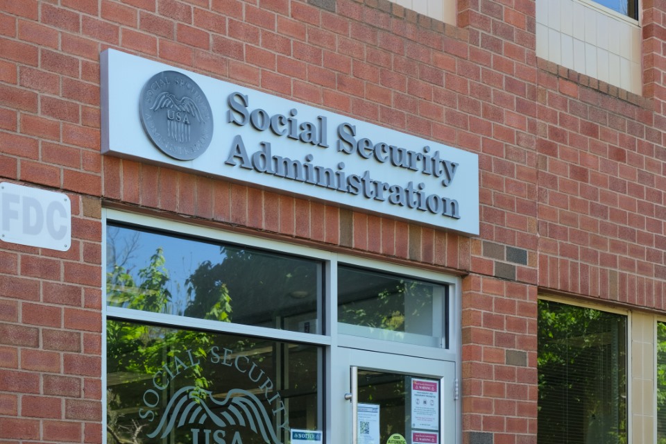 The exterior of a Social Security Administration office on a clear day, with pedestrians near the entrance